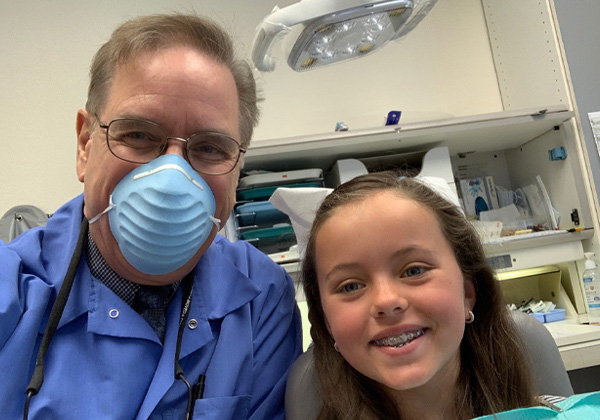 Dr. and a young patient with braces.